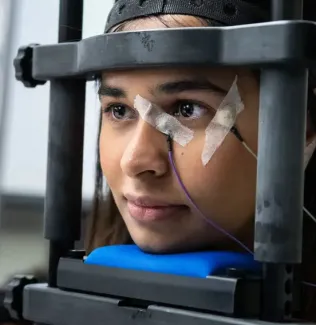Student wearing a machine on her head in the neuroscience lab